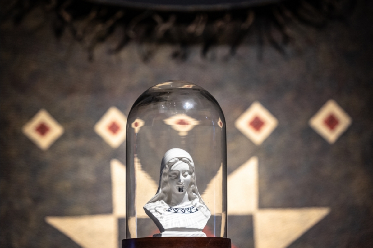 A religious icon from a thrift store sits under a glass dome