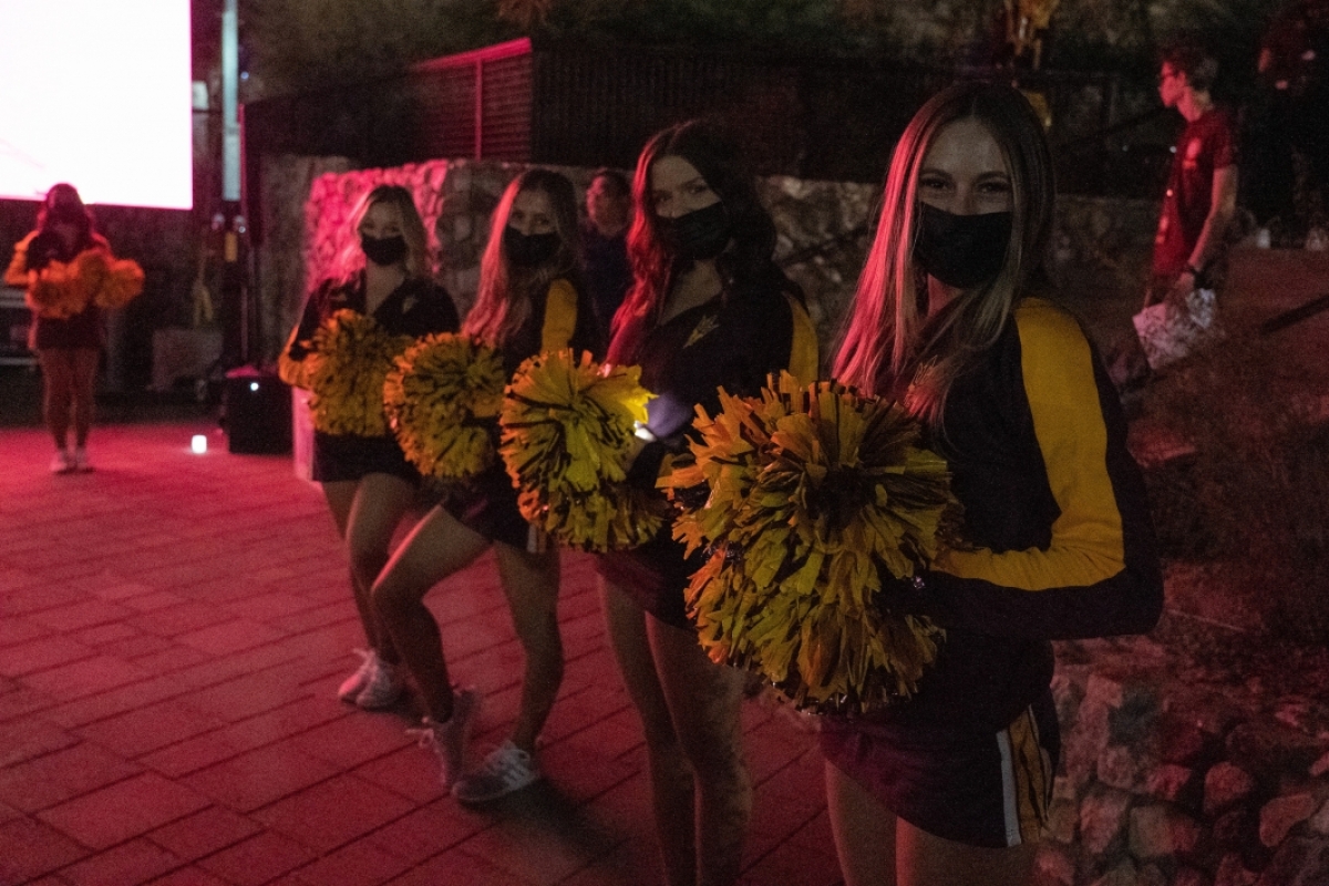 Four cheerleaders wearing masks at the Lantern Walk