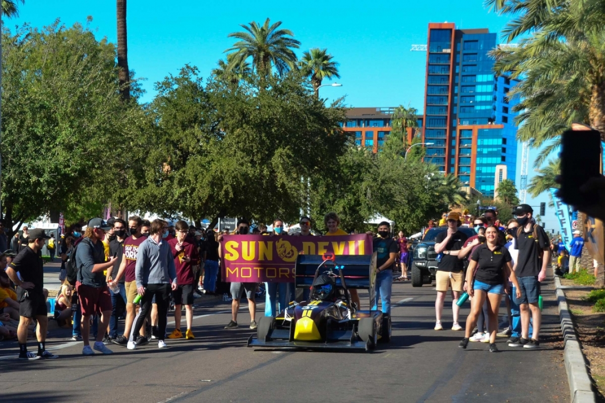 A race car drives in the Homecoming parade