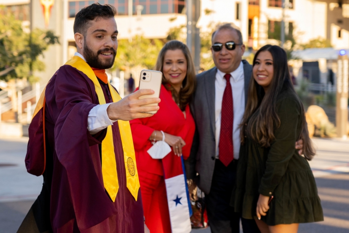 graduate taking a selfie with his family