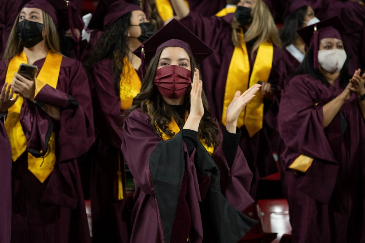 student clapping at graduation ceremony