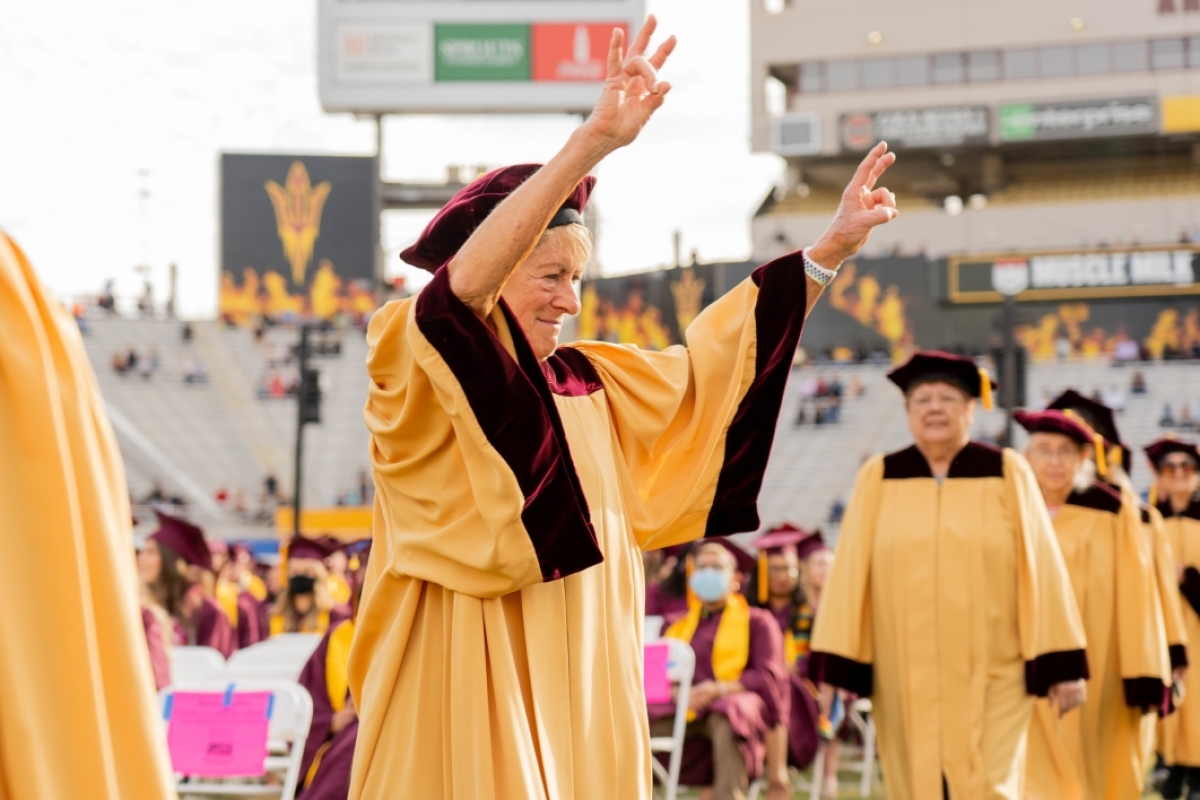 ASU Golden Grad flashing pitchfork with hands at graduation