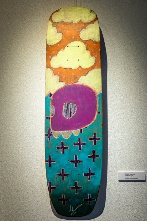 Skateboard painted with clouds and abstract images.