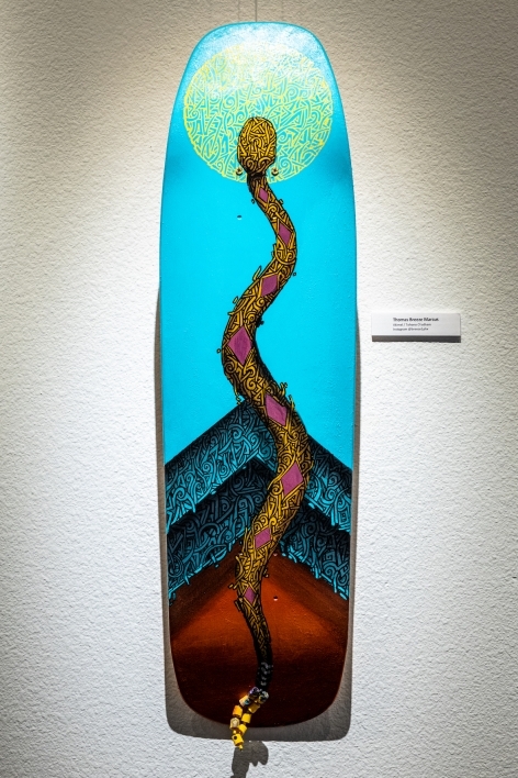 Skateboard painted with an image of a snake.