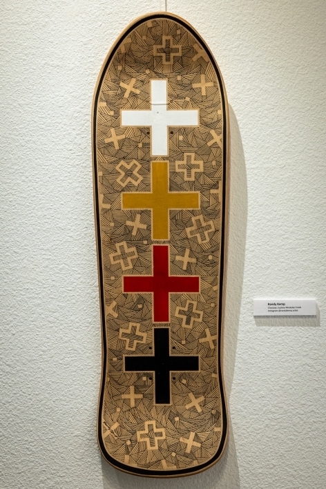 Skateboard painted with images of crosses.