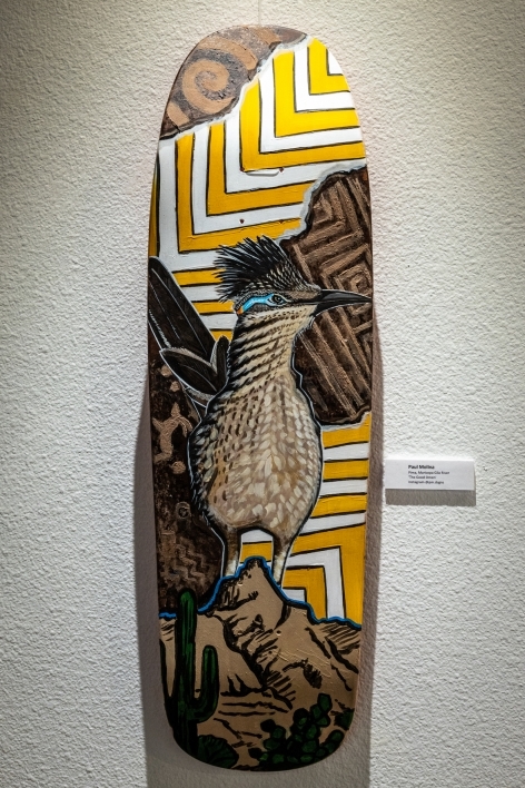 Skateboard painted with an image of a roadrunner, with abstract shapes in the background.
