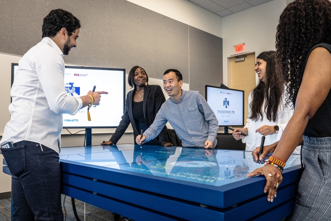 People standing around large touchscreen table