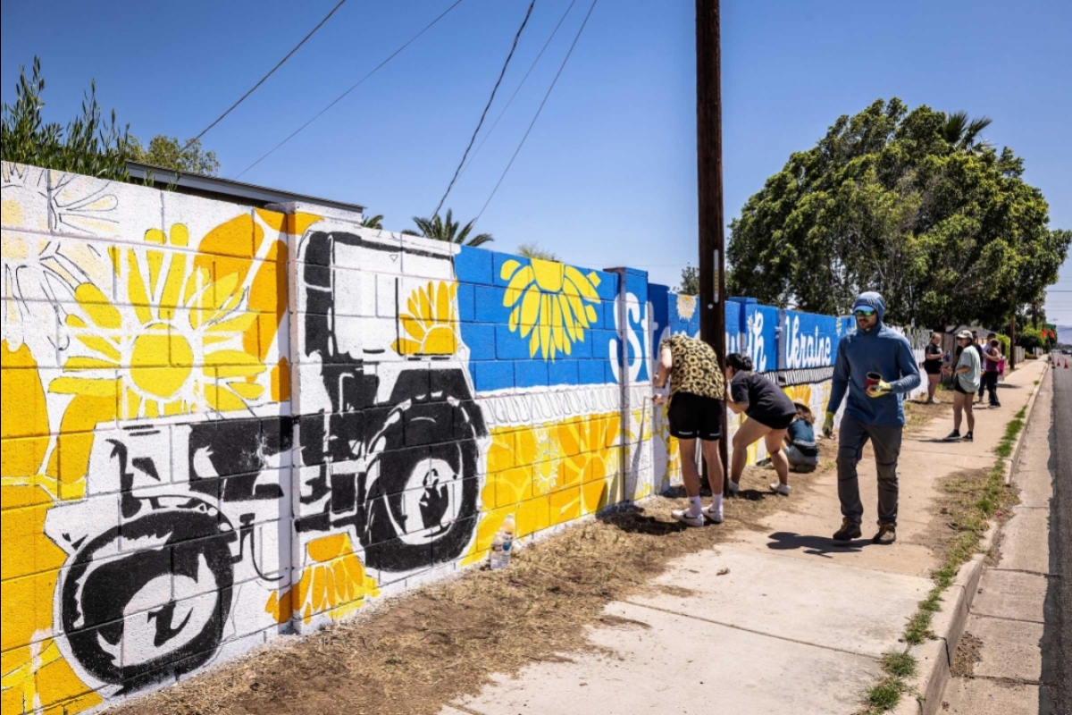 A wall mural for Ukraine with a tractor on it and a sunflower