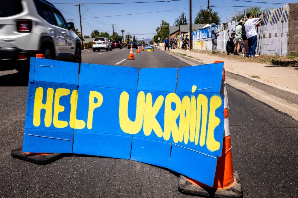 Cardboard sign on street that says Help Ukraine