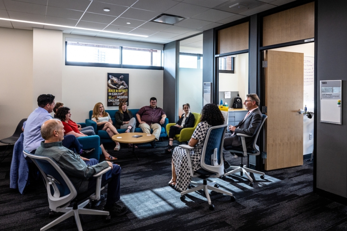 Humanities faculty and staff members informally gather in a collaborative meeting space 