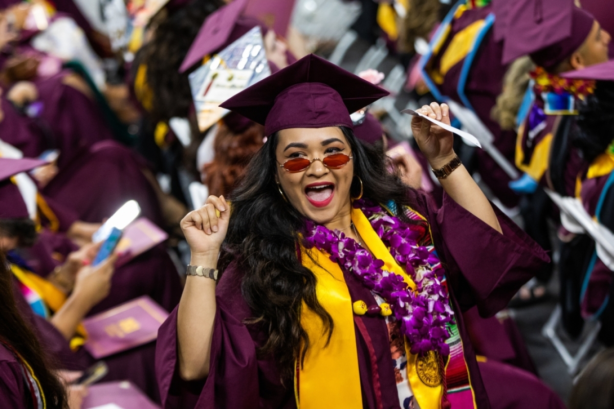 Female graduate at Hispanic convocation makes a cheer