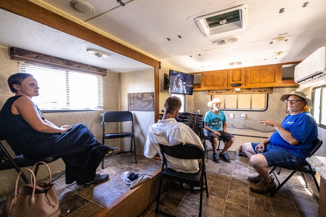People sit inside trailer talking