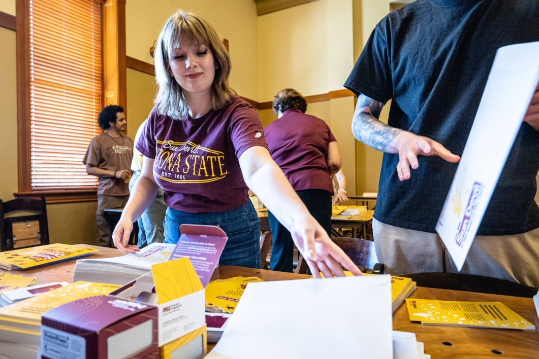 woman finishing up envelope with ASU swag