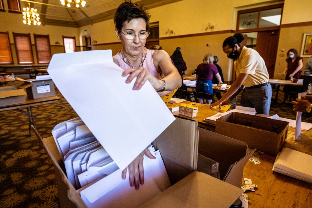 woman pulling envelope out of box