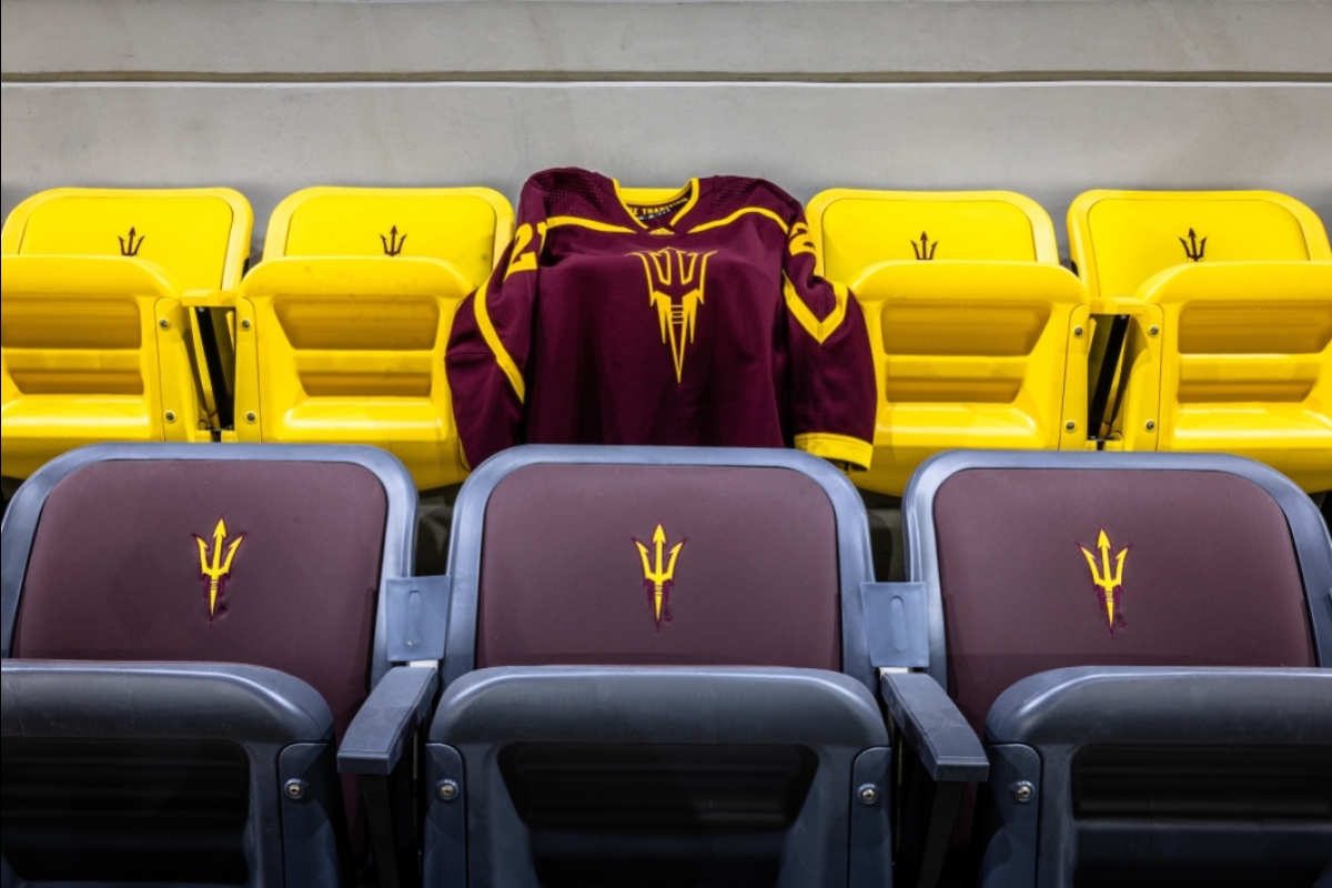 An ASU hockey jersey is thrown over rows of maroon and gold seats with pitchforks on them