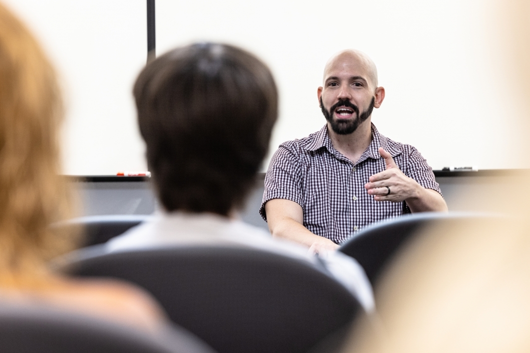man speaks to classroom of students