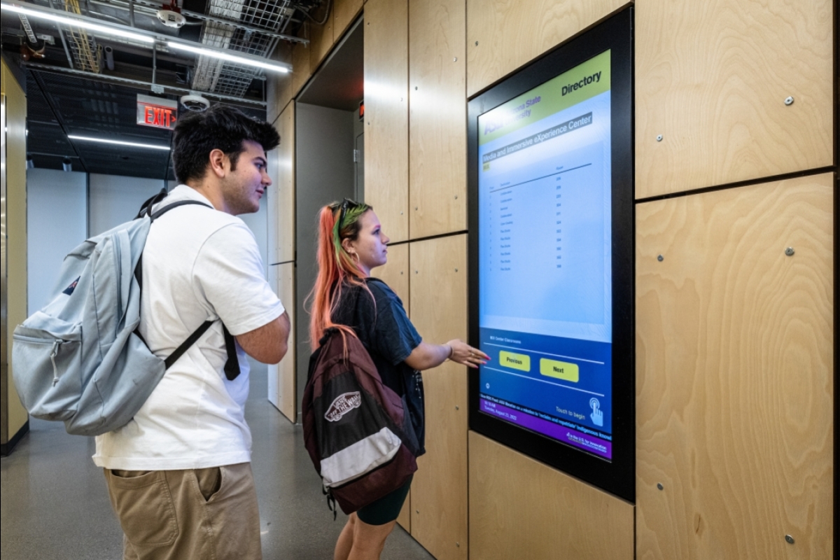 Two students interacting with directory display screen