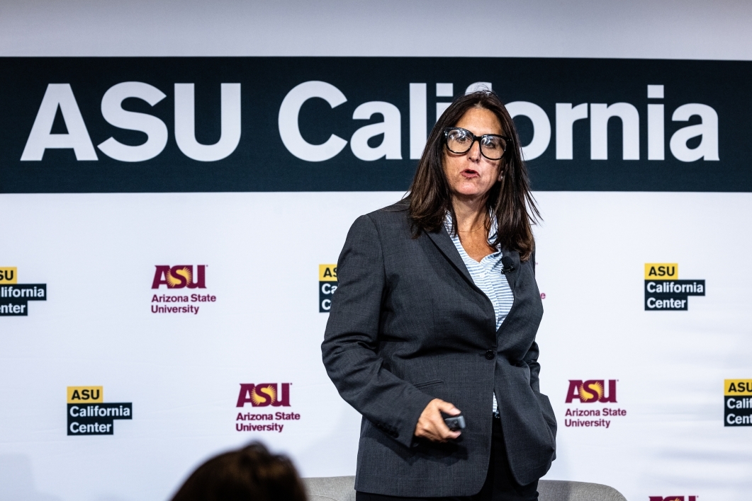 Woman speaking in front of ASU backdrop at event