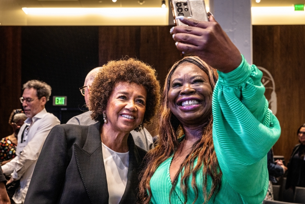 Two women posing for a selfie with a cell phone