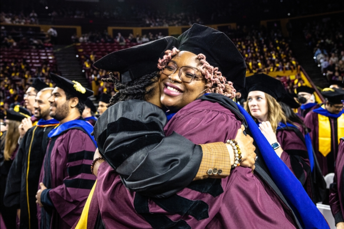Graduate and professor hugging at commencement