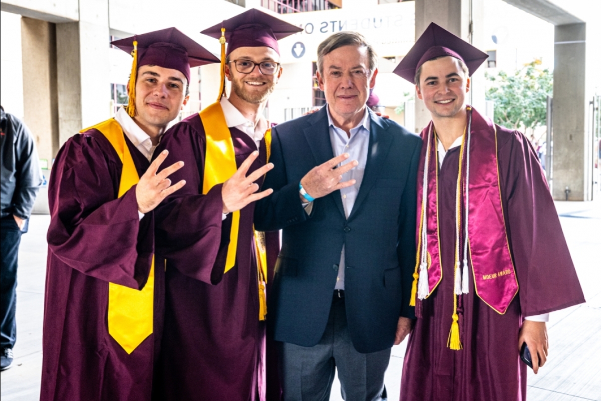ASU President Crow poses with three grads