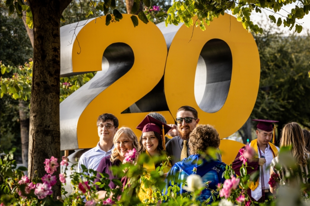 A group poses in front of a large gold 2022 sign