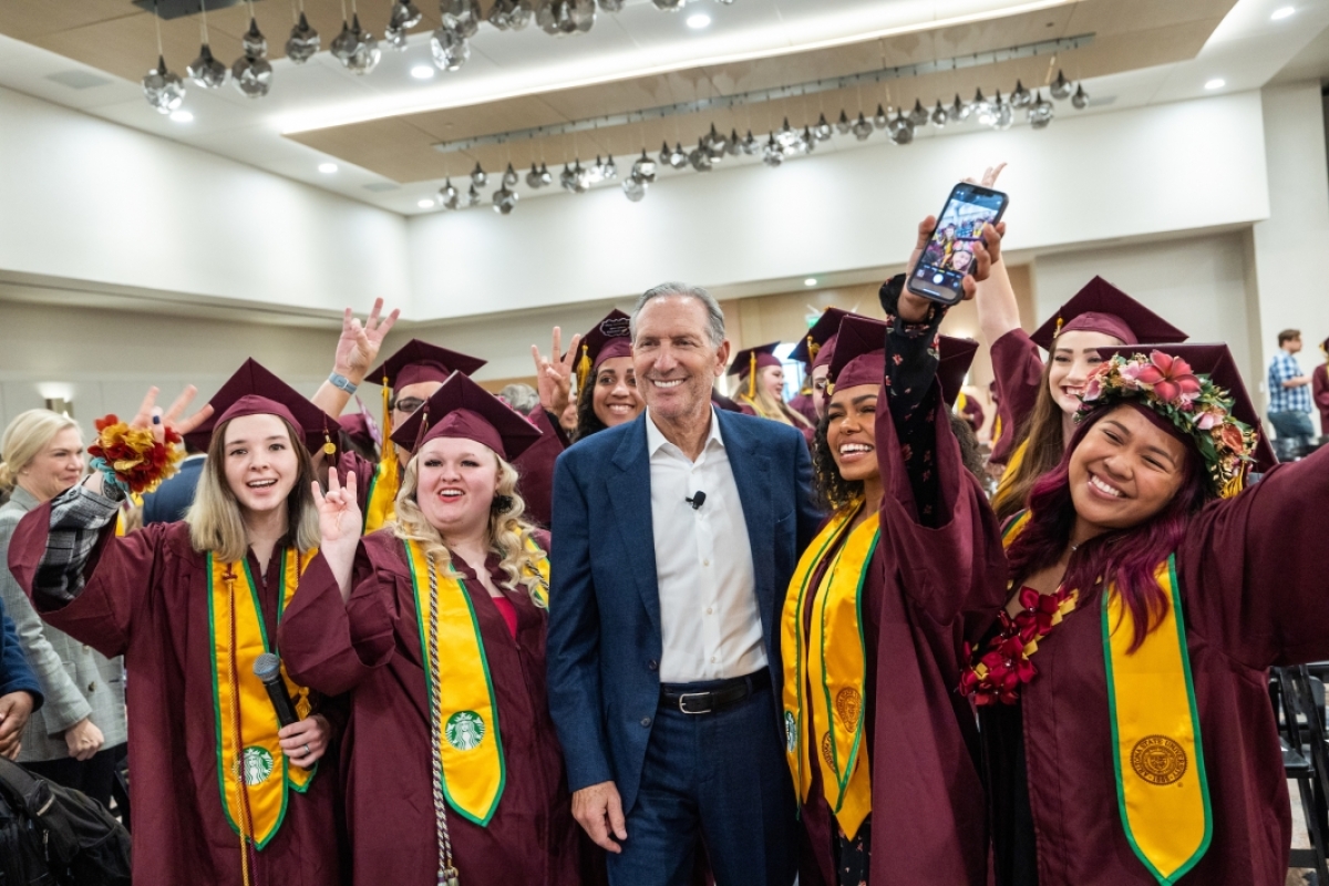 ASU graduates pose for a photo with Howard Schultz