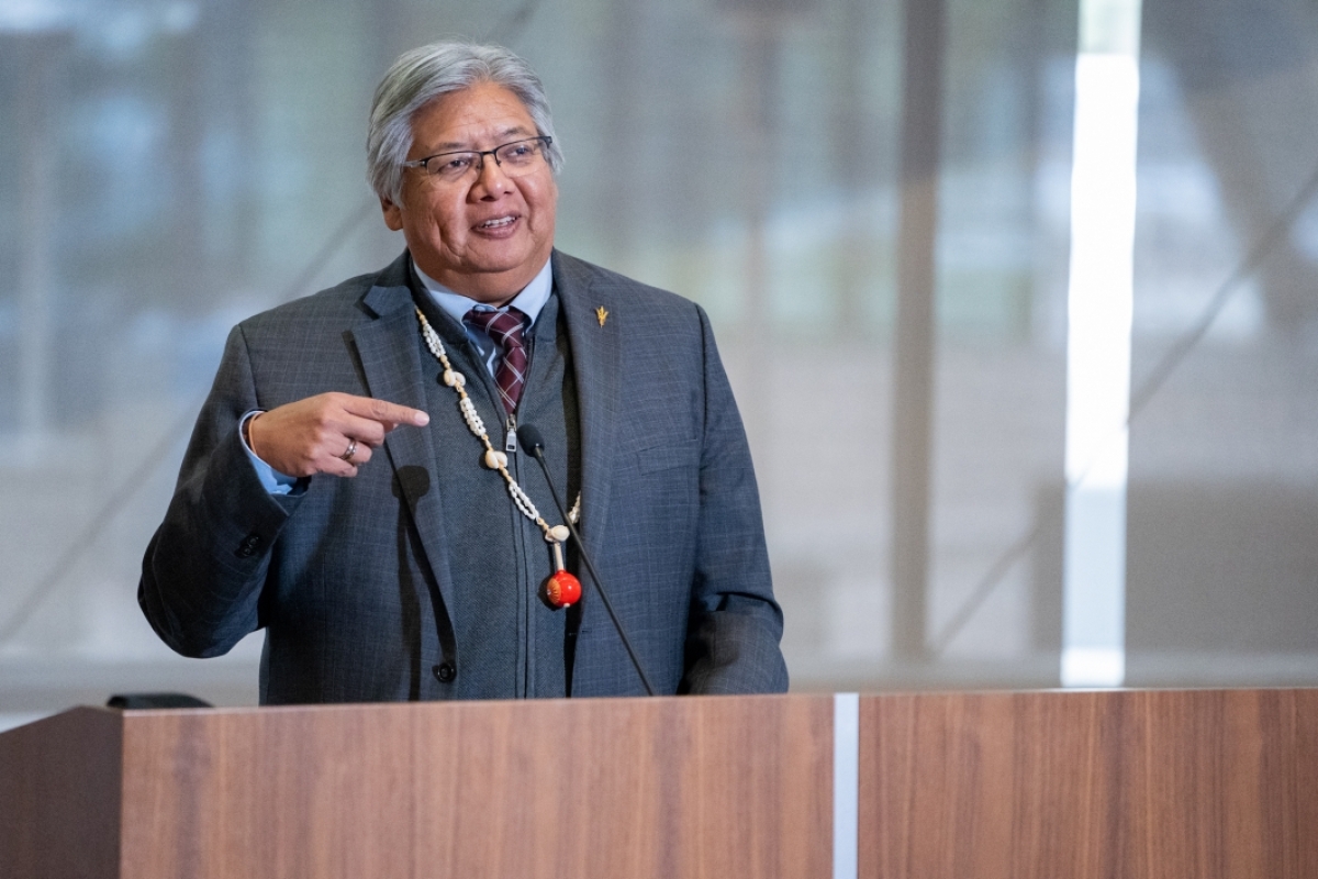 Indigenous man speaking at a podium.