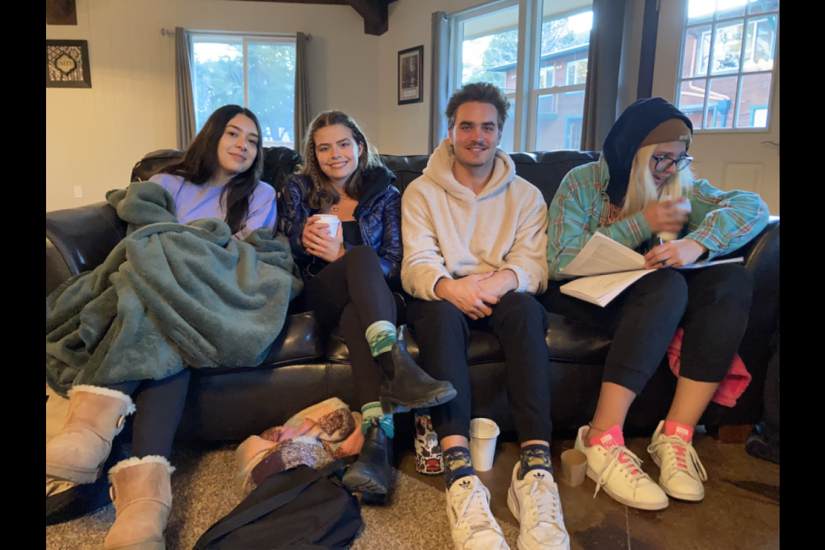 Group of students sitting on a couch and smiling.