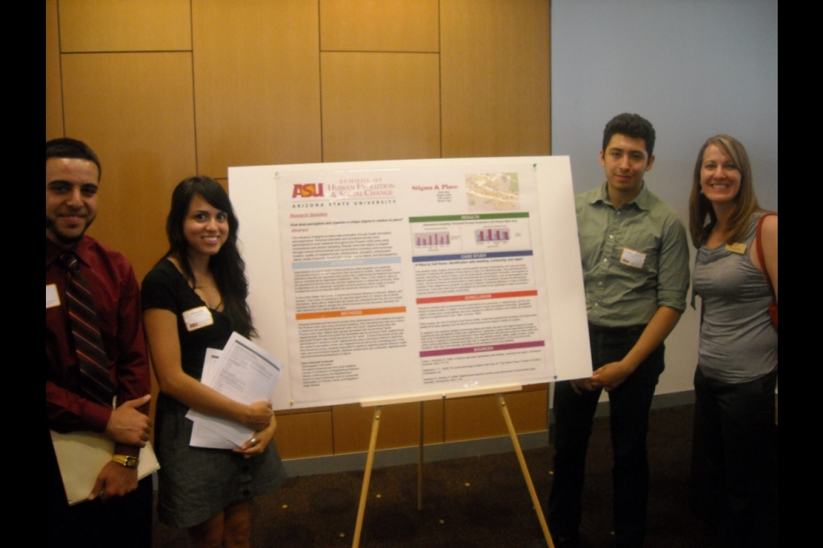 Students standing next to a poster board.