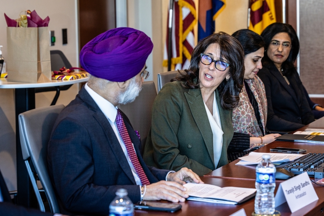 Woman talking to ambassador from India at a conference table