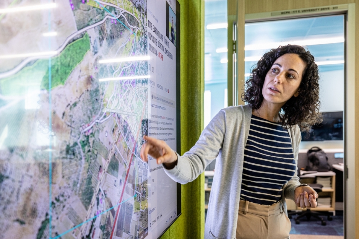 Woman pointing to large map on screen