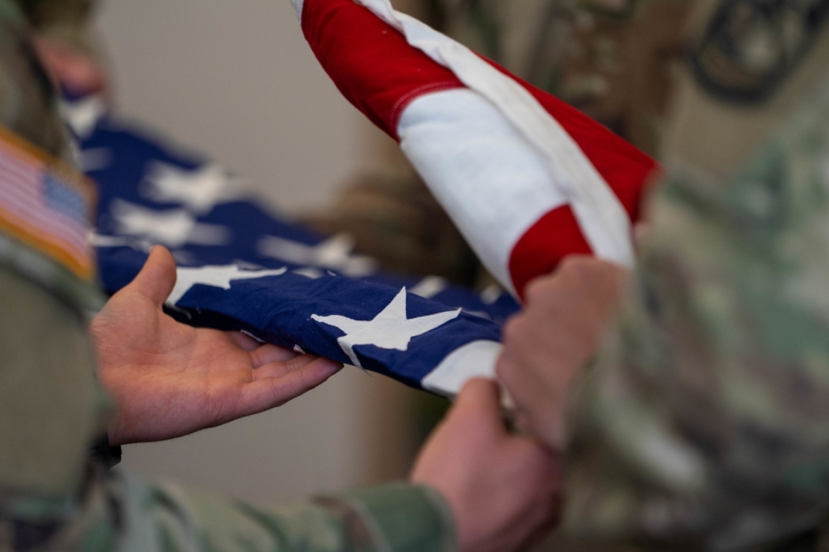 Hands folding a US flag