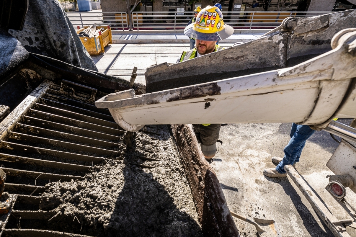 A construction worker pours concrete