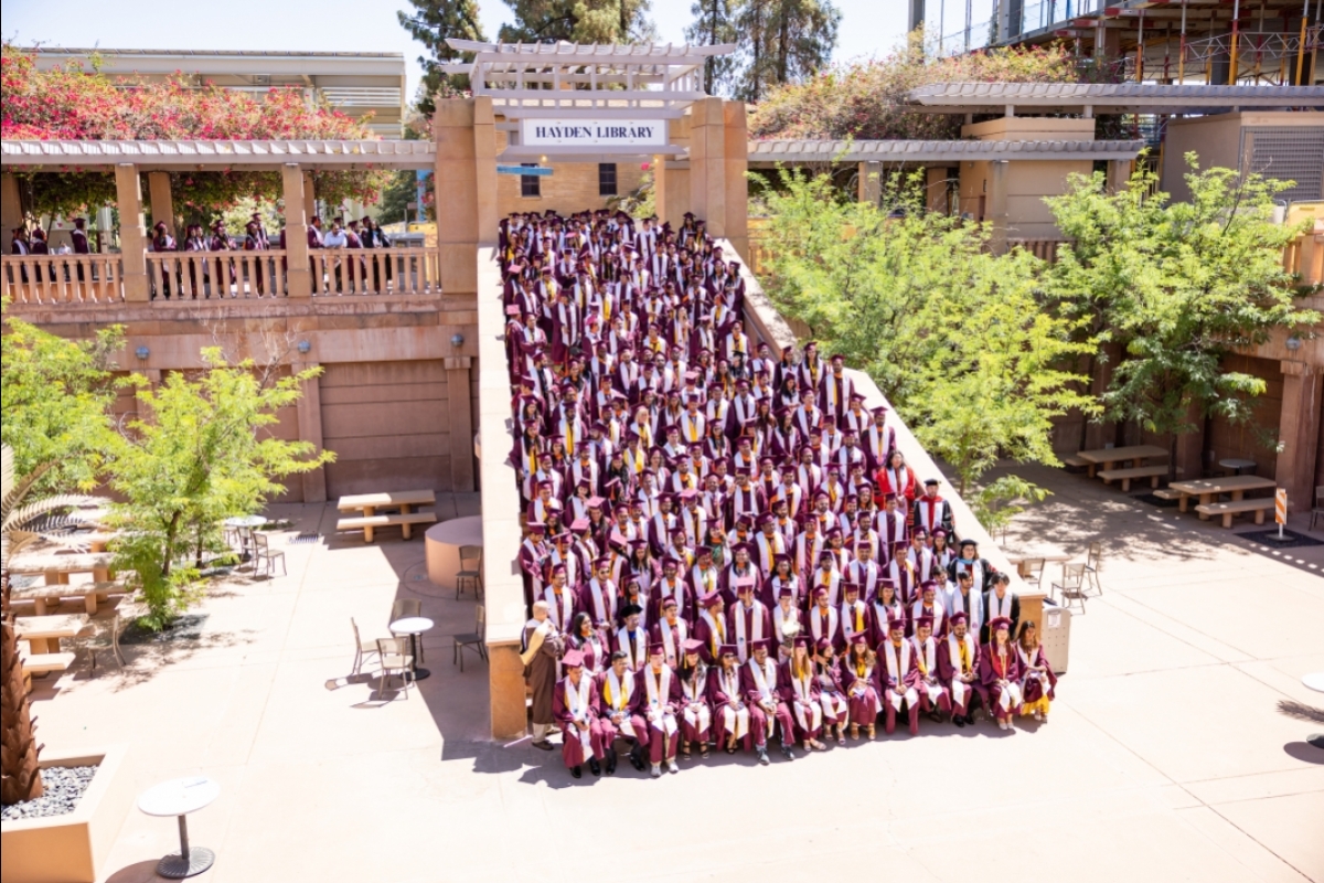 Group of graduates posing on Hayden Library outdoor stairs