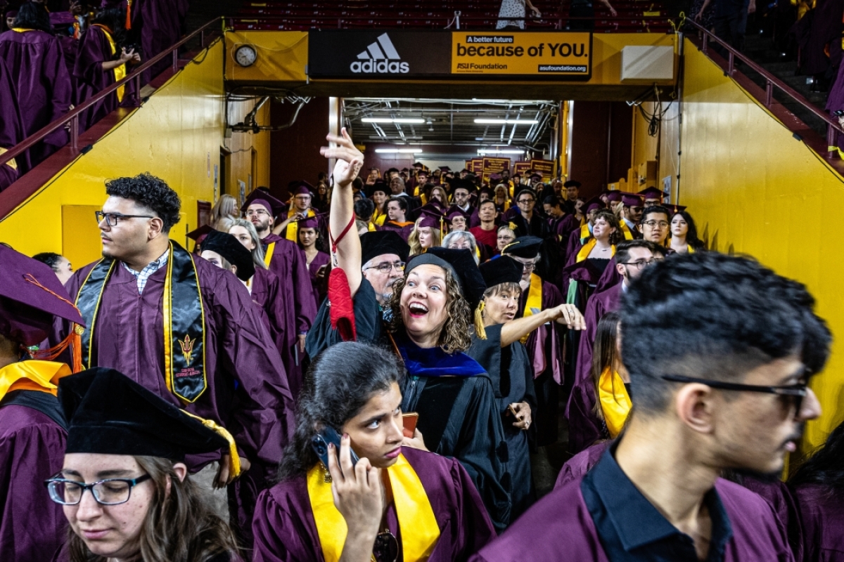 Graduates coming through tunnel at basketball arena