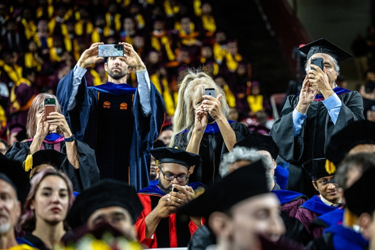 Professors taking pictures during graduate commencement