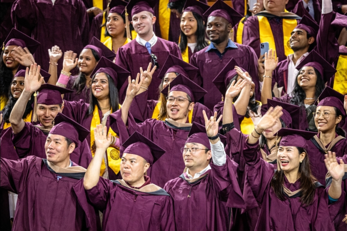 Crowd of grads in maroon caps and gowns at Graduate Commencement