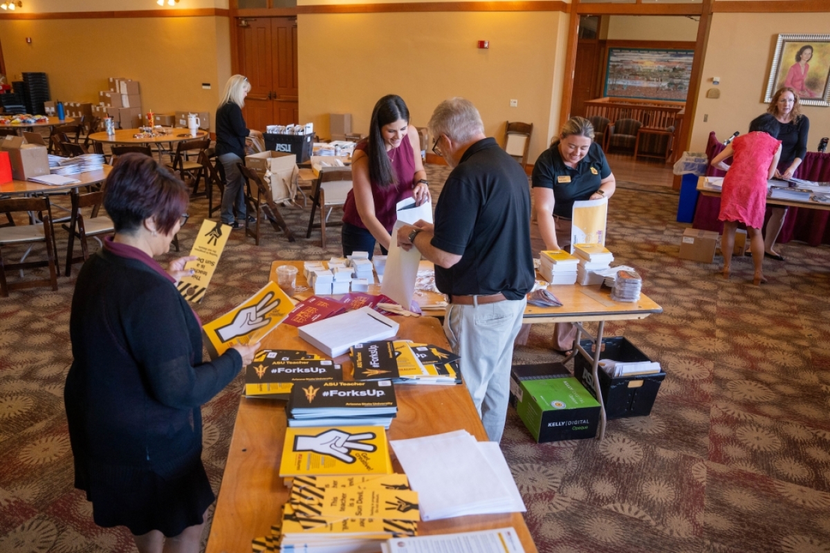 People packing envelopes with ASU promotional material.