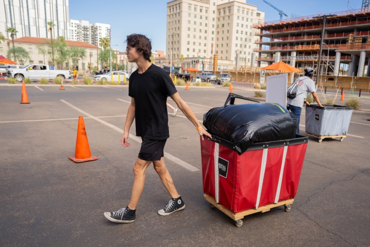 Student pulling cart full of belongings during move-in
