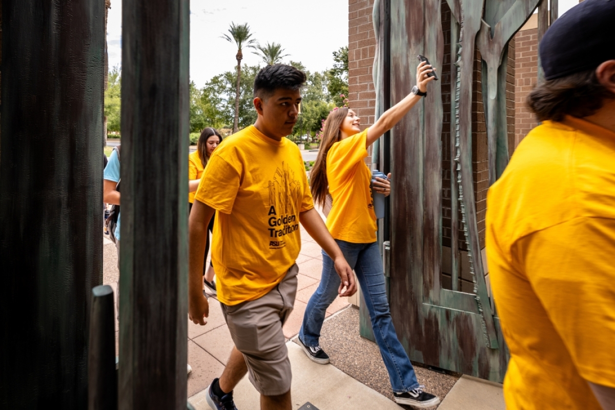 Students walking through copper gates on ASU West campus