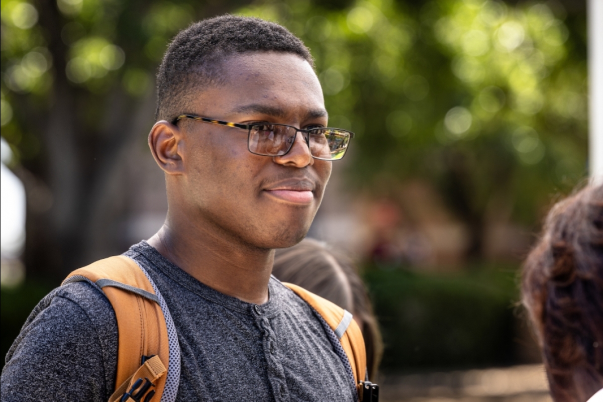 Portrait of Black student wearing a backpack and glasses