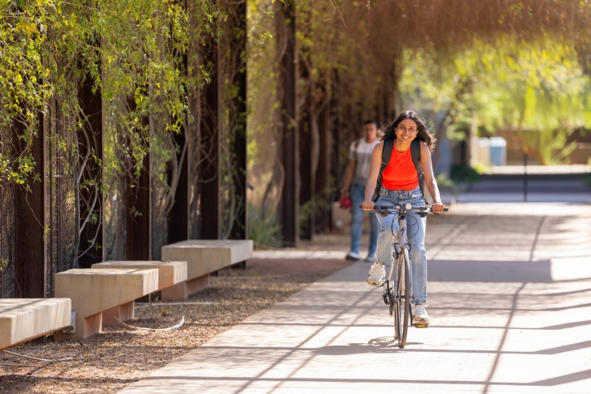 Student riding bike on campus