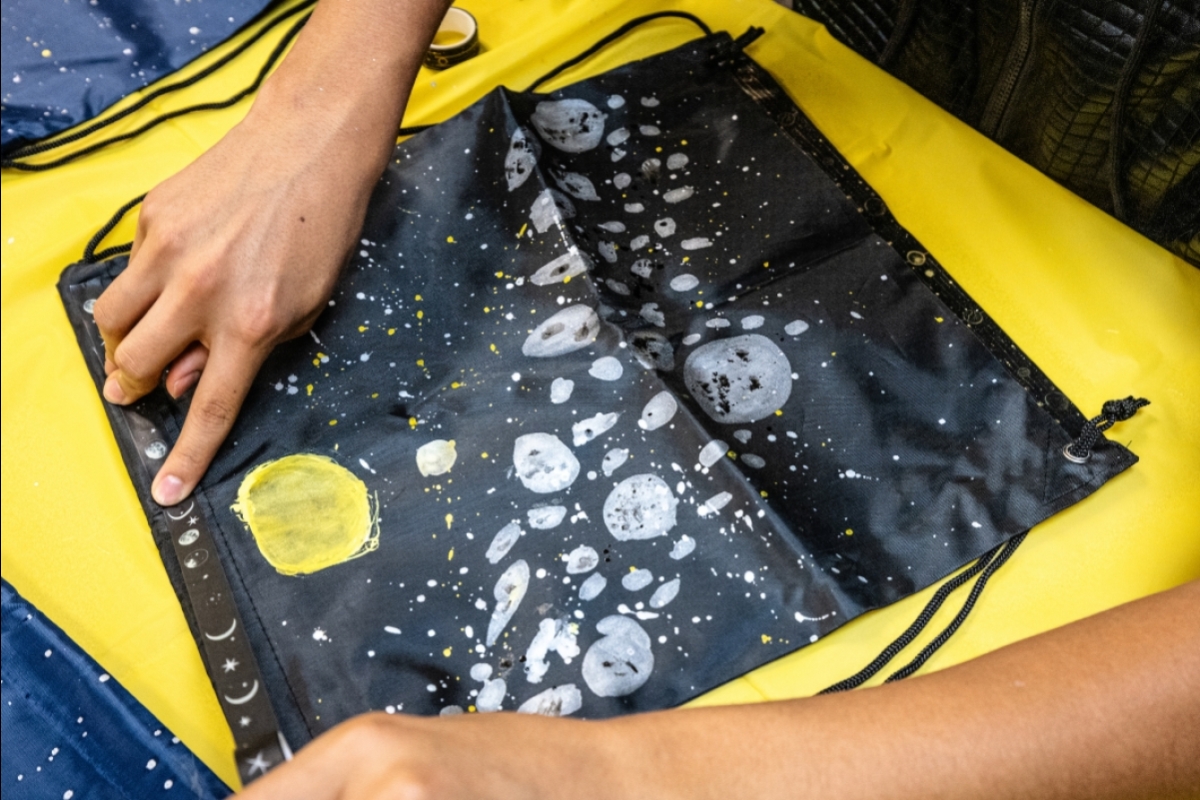 A bag with asteroids drawn all over it