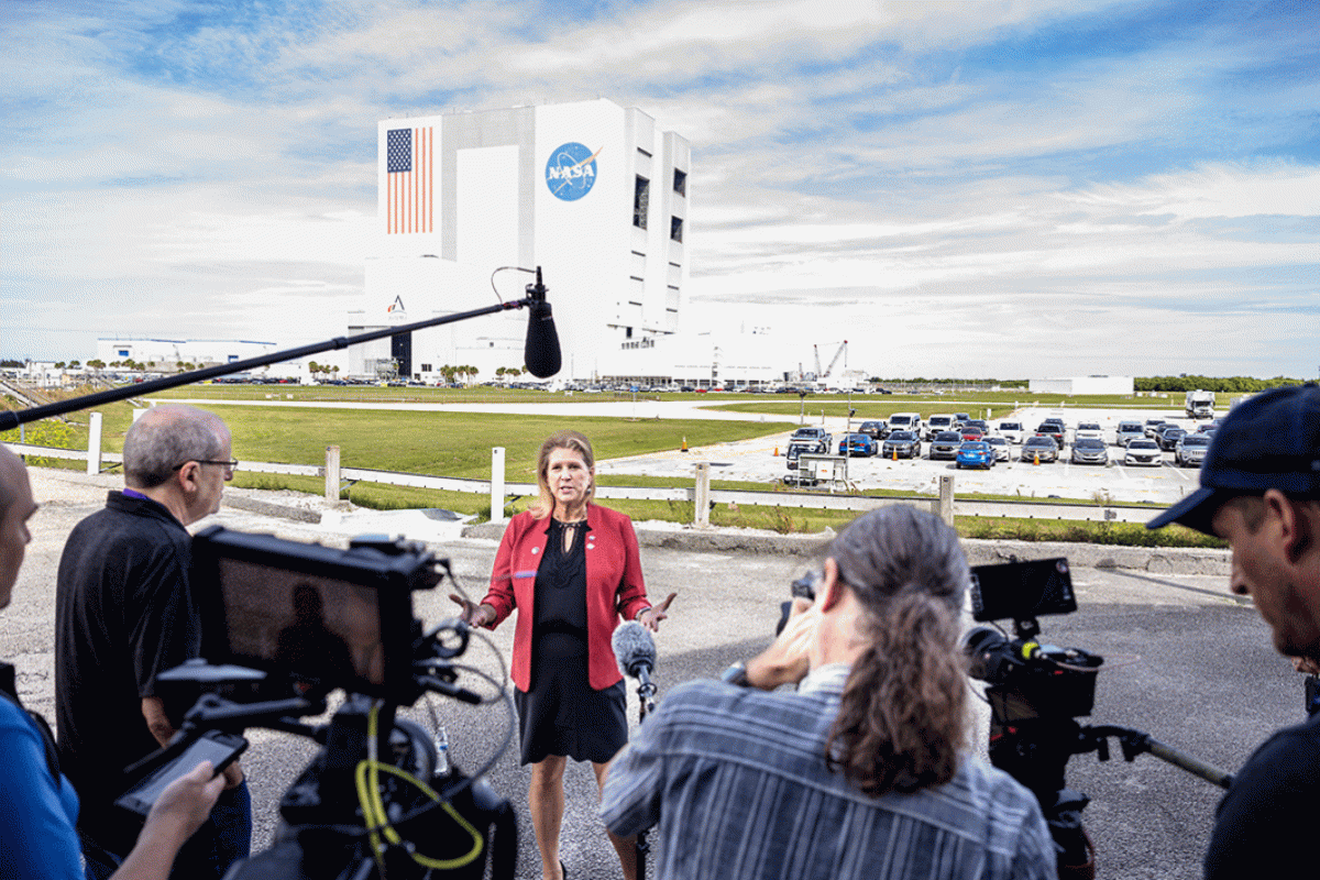 A woman standing in front of a NASA building speaks to media