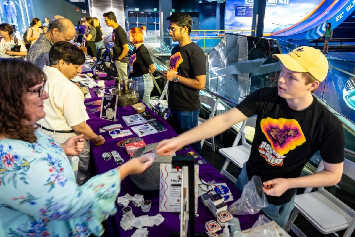 College students speak to visitors at a NASA tabling event