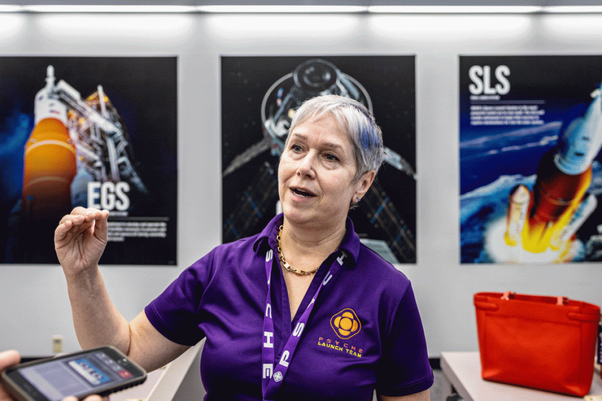 A woman speaks in front of NASA displays