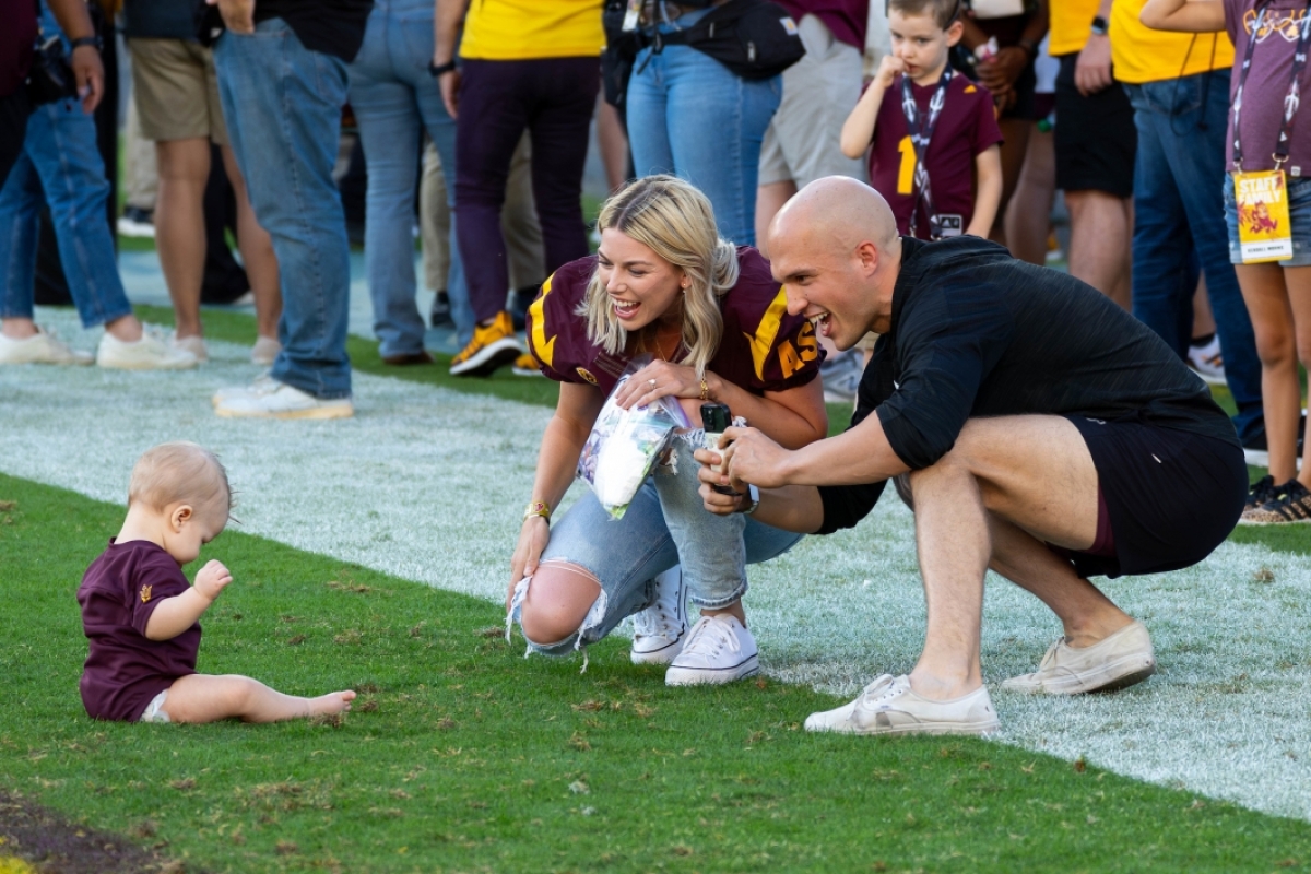 Parents take photo of baby on football field
