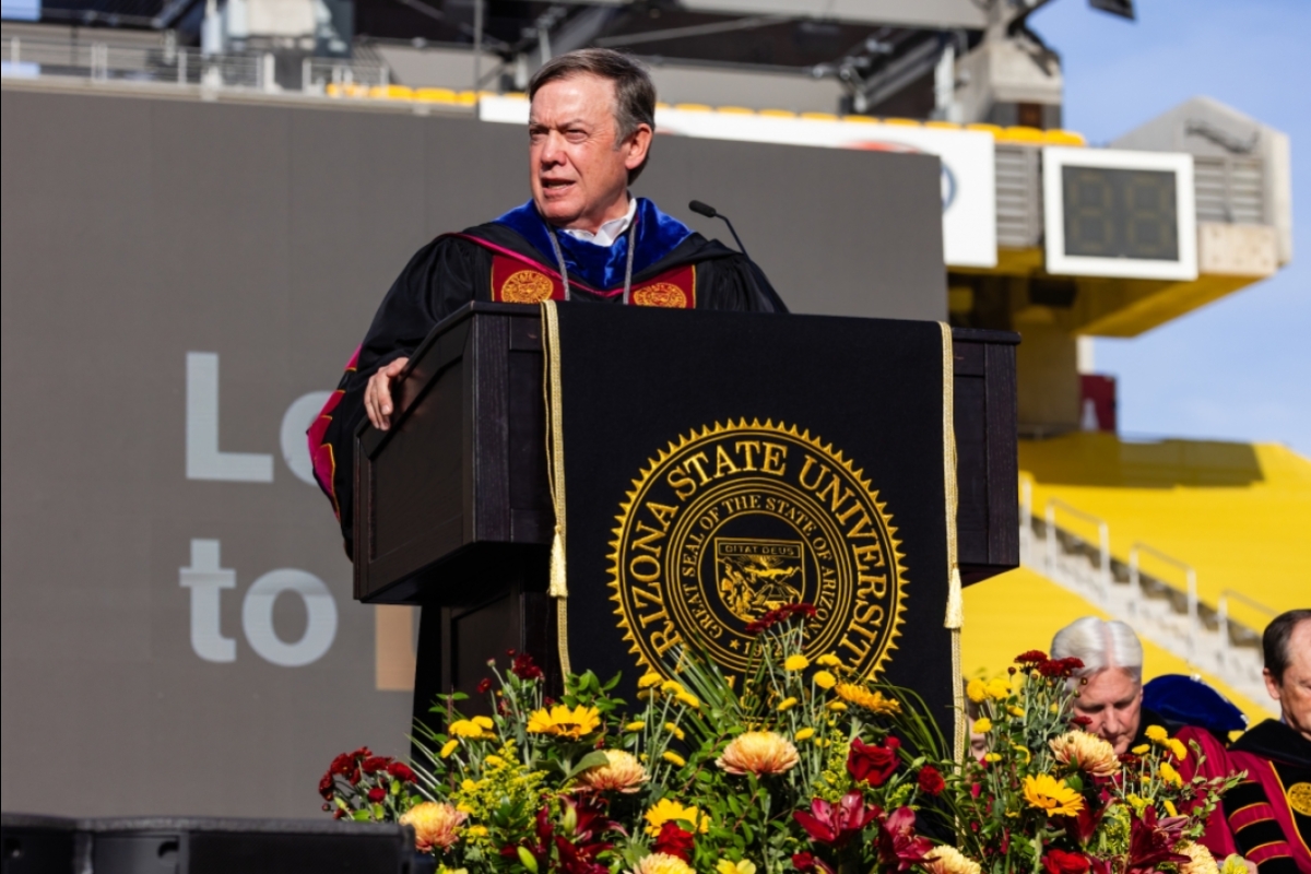 ASU President Michael Crow speaks behind lectern at ASU commencement