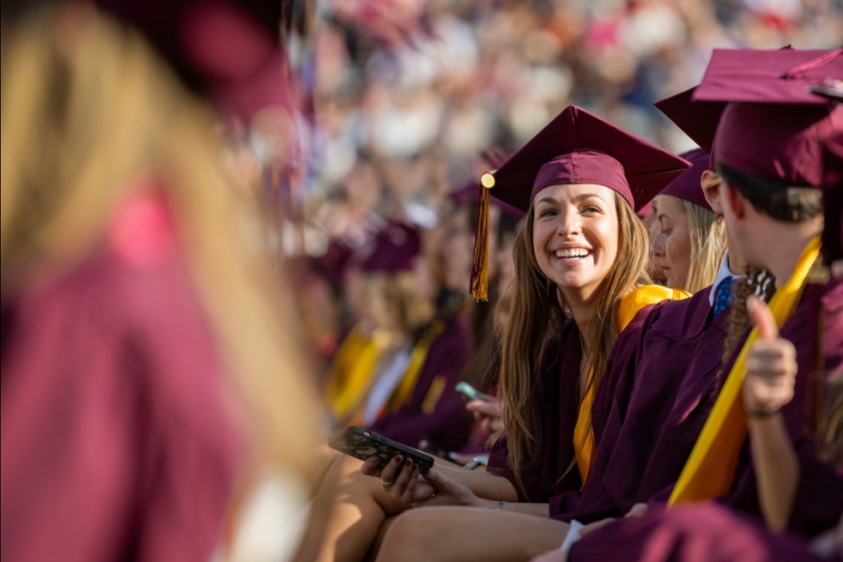 ASU graduate in cap and gown looks to crowd during commencement